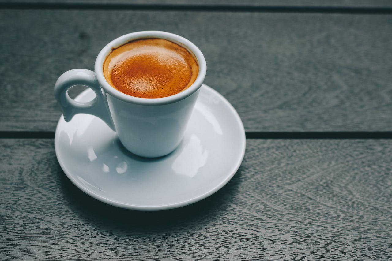 A stylish espresso in a porcelain cup on a wooden table, perfect for coffee lovers.